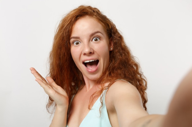 Close up Young excited redhead woman girl in casual light clothes posing isolated on white background studio portrai. People lifestyle concept. Mock up copy space. Keeping mouth open, spreading hands.