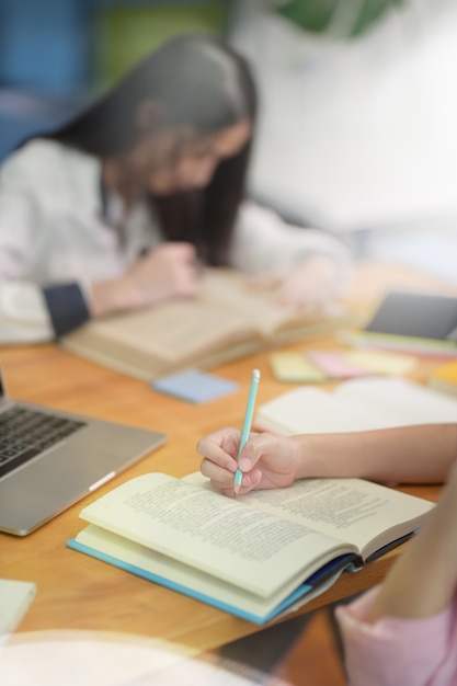 Close-up of young girl hand's taking notes 