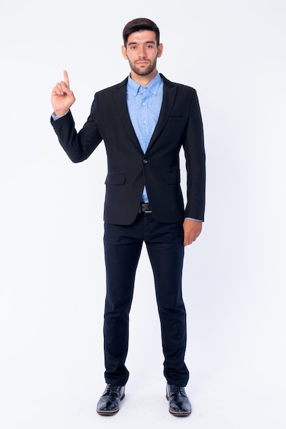 Close up of young handsome bearded Persian businessman in suit isolated