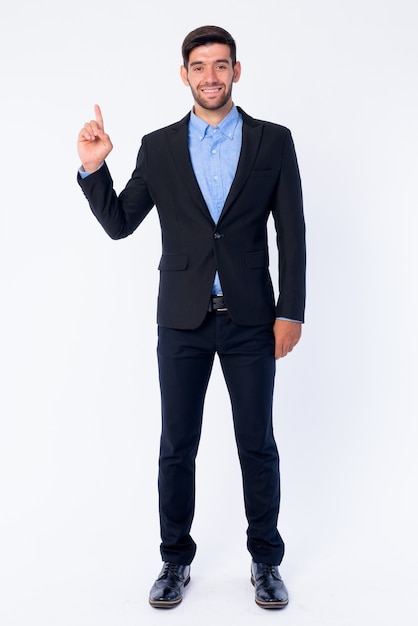 Close up of young handsome bearded Persian businessman in suit isolated