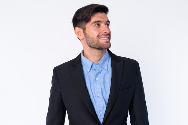 Close up of young handsome bearded Persian businessman in suit isolated