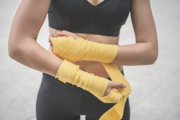 Close up of a young handsome caucasian brown hair woman wrapping her hands with a band