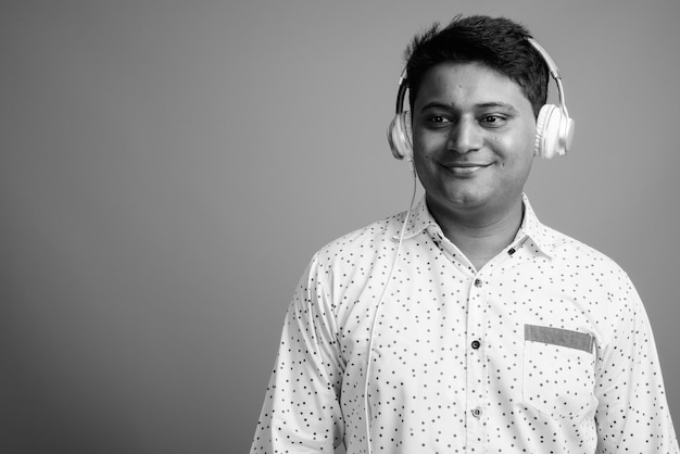 Close up of young Indian businessman listening to music