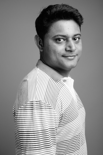 Close up of young Indian man wearing long sleeve striped polo shirt 