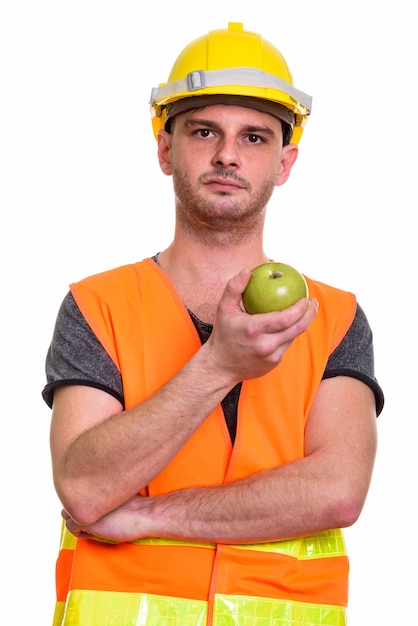 녹색 사과 들고 젊은 남자 건설 노동자의 클로즈업