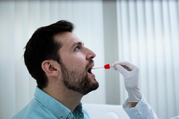코로나 바이러스 전염병 동안 의사 사무실에서 PCR 테스트를하는 젊은 남자의 닫습니다