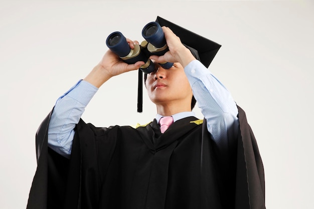 백색 배경 에 비추어  ⁇ 안경 을 사용 하여 졸업식 의 옷 을 입은 젊은 남자 의 클로즈업