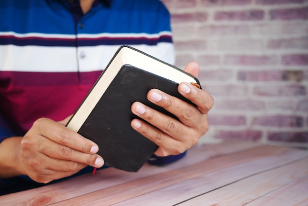 Primo piano della mano del giovane che legge un libro