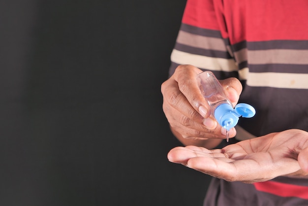 Close up of young man hand using sanitizer gel for preventing virus.