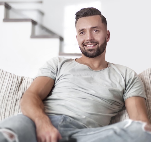 Close up young man sitting on sofa