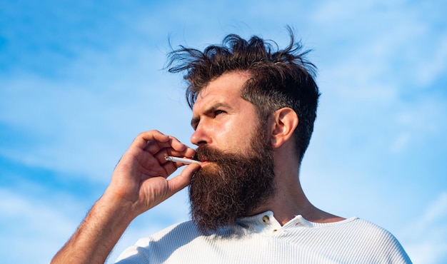 Close up young man smoking a cigarette.