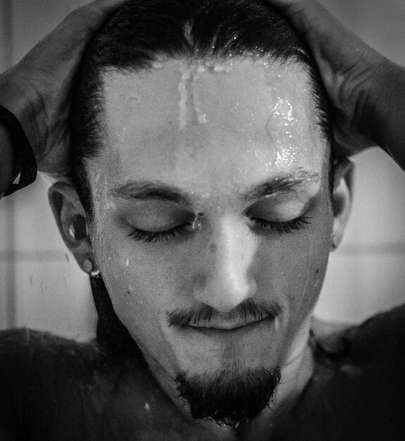 Photo close-up of young man taking bath at home