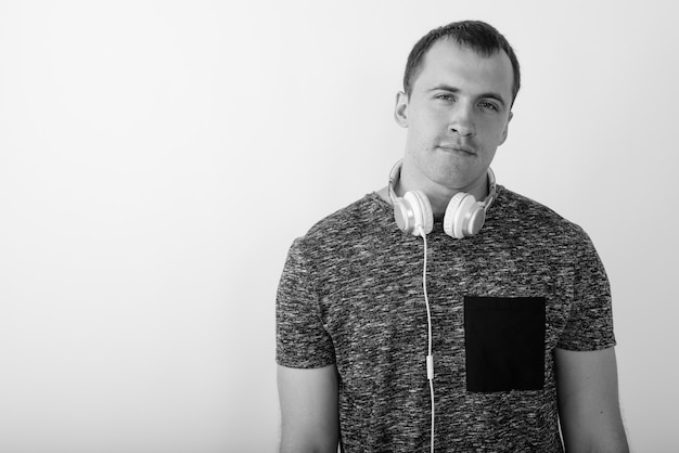 Close up of young muscular man isolated wearing headphones around neck