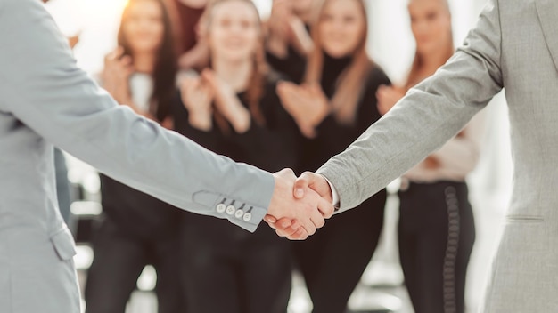 Close up young people shaking hands at a group meeting