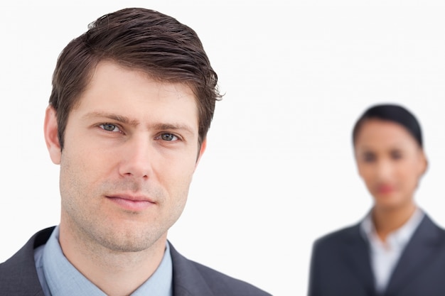 Close up of young salesman with colleague behind him