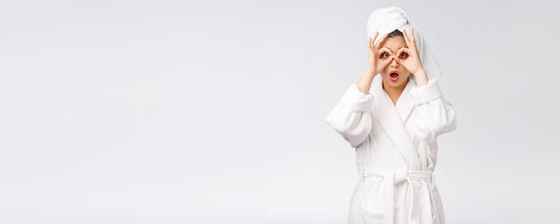 Close up of young smiling woman with finger ok gesture on eyes isolated on white background