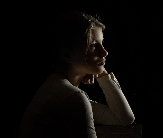 Photo close-up of young woman against black background