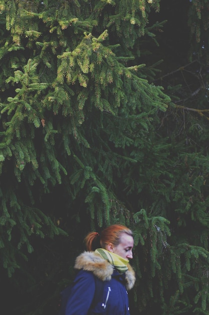 Foto close-up di una giovane donna contro gli alberi