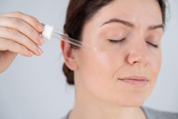 Photo close-up of young woman applying make-up