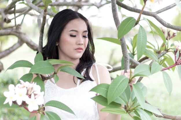 Foto close-up di una giovane donna con fiori in fiore