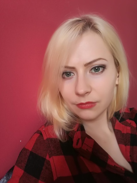 Close-up of young woman by red wall