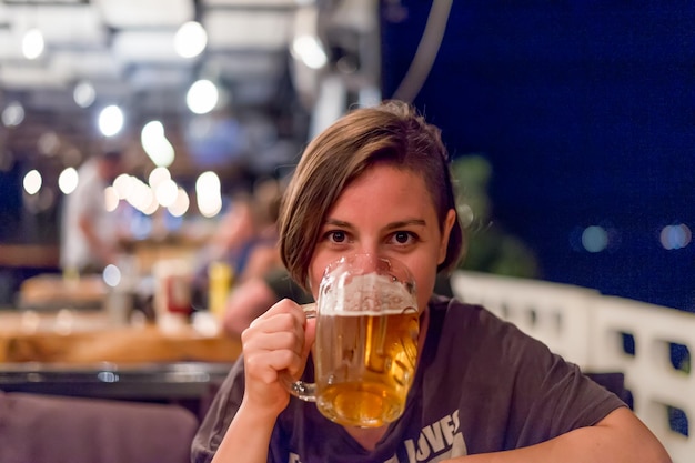 Photo close-up of young woman drinking beer