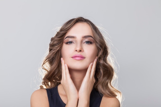 Close up of young woman gently touching her face