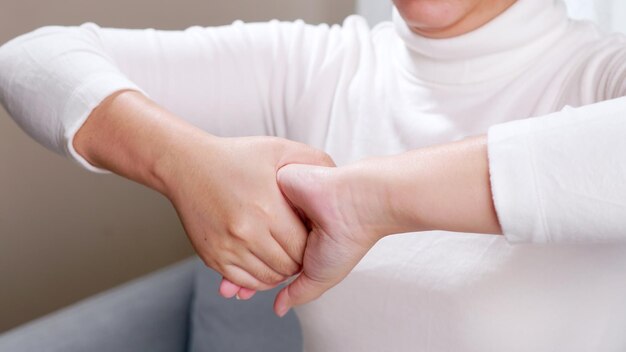 Close up of young woman hands doing hand massage by herself for soothing and relaxing