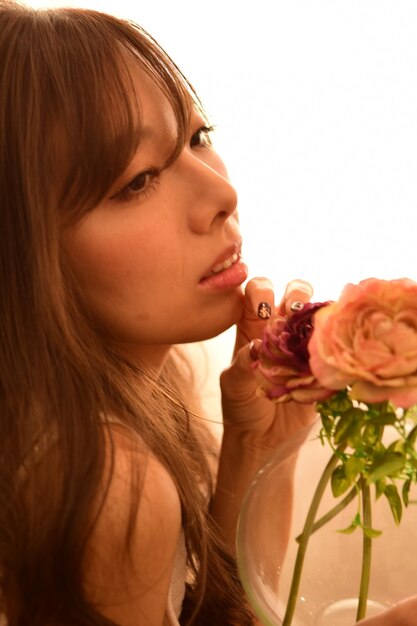 Foto close-up di una giovane donna che tiene una rosa a casa