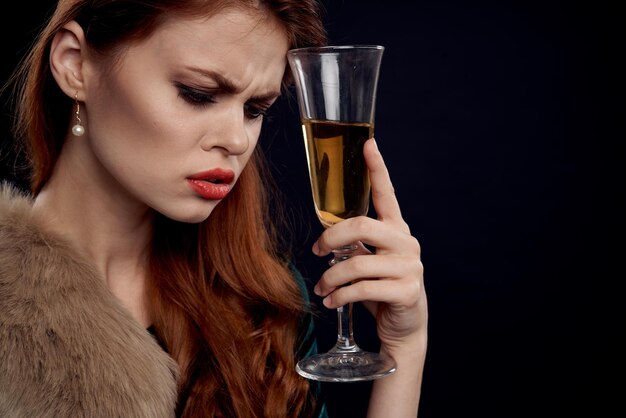 Close-up of young woman holding wineglass against black background