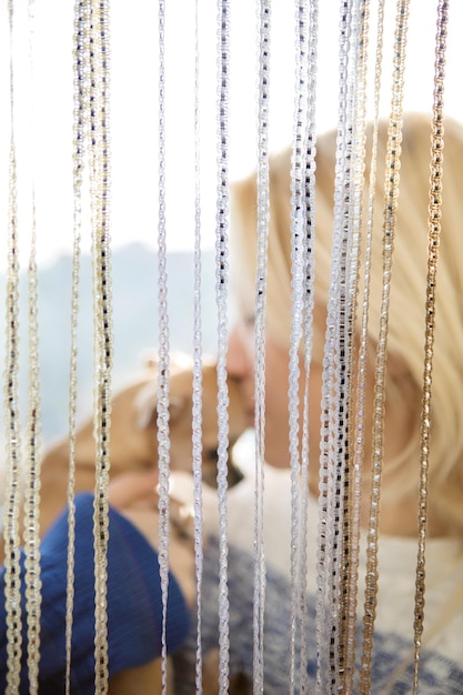 Photo close-up of young woman kissing chihuahua seen through decorations