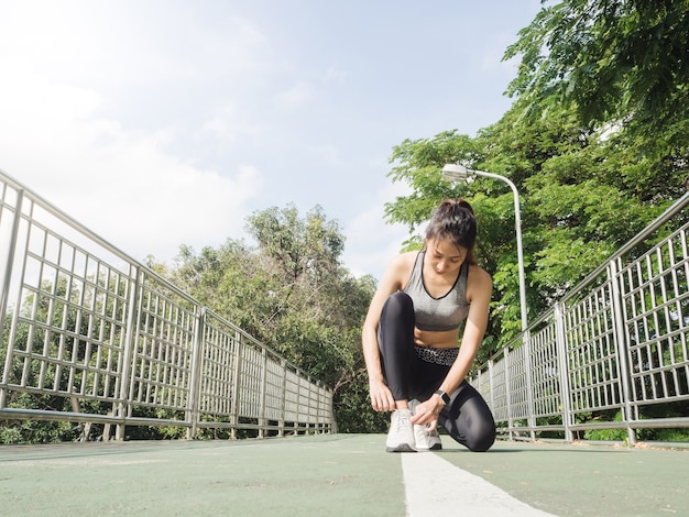 公園の中でエクササイズする準備ができている彼女の靴の上に若い女性のレースのクローズアップ