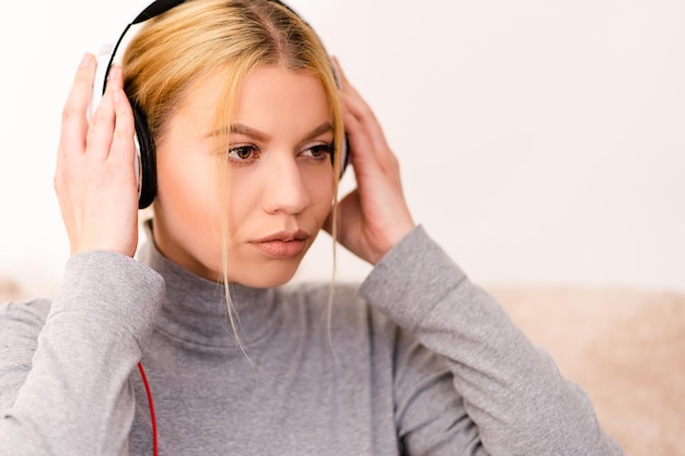 Photo close-up of young woman listening to music while sitting at home