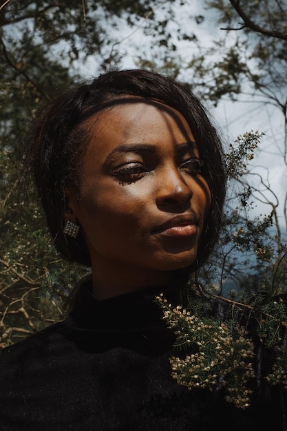 Foto close-up di una giovane donna che guarda lontano nella foresta