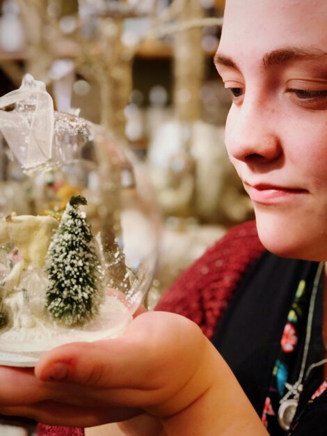 Close-up of young woman looking at snow globe