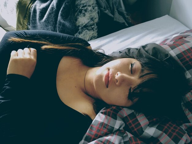 Photo close-up of young woman lying on bed