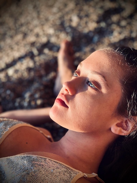 Photo close-up of young woman lying on sand