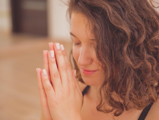 Foto close-up di una giovane donna che medita in uno studio di yoga