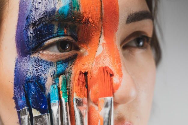 Close-up of young woman painting face