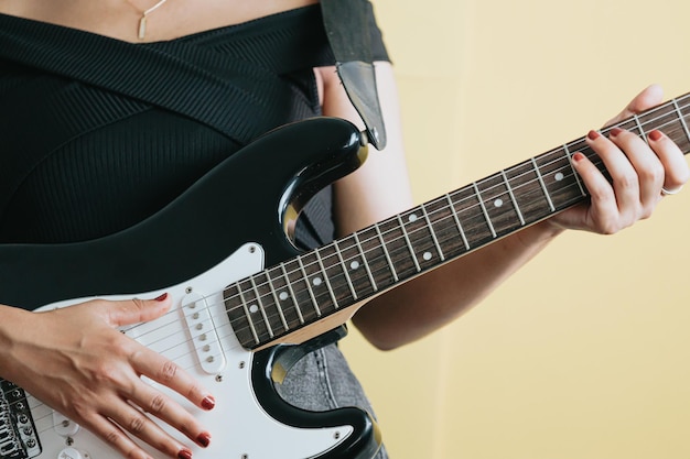 Close up of a young woman pair of hands playing a guitar\
outdoors. sunny day and practicing an instrument concept. copy\
space music life on tour and nature.