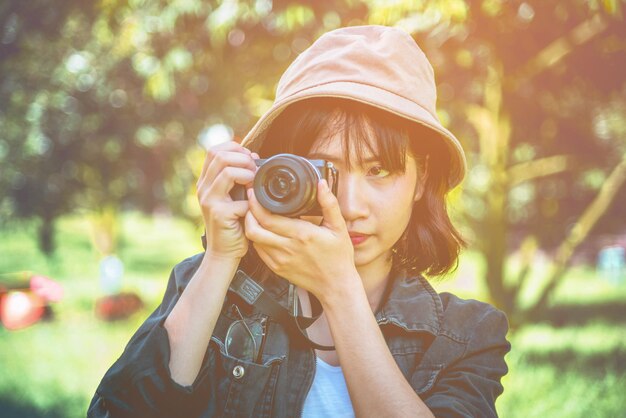 カメラを通して写真を撮っている若い女性のクローズアップ