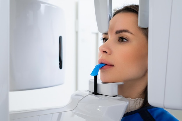 Close up of young woman receiving panoramic teeth xray in dentists office