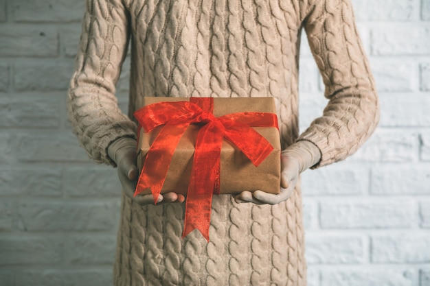 Close up on young woman in rubber gloves holding a gift