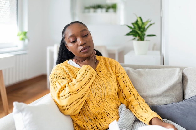 Close up of young woman rubbing her inflamed tonsils, tonsilitis problem, cropped. Woman with thyroid gland problem, touching her neck, girl has a sore throat