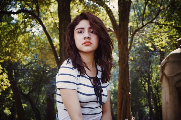 close-up of young woman sitting amidst trees