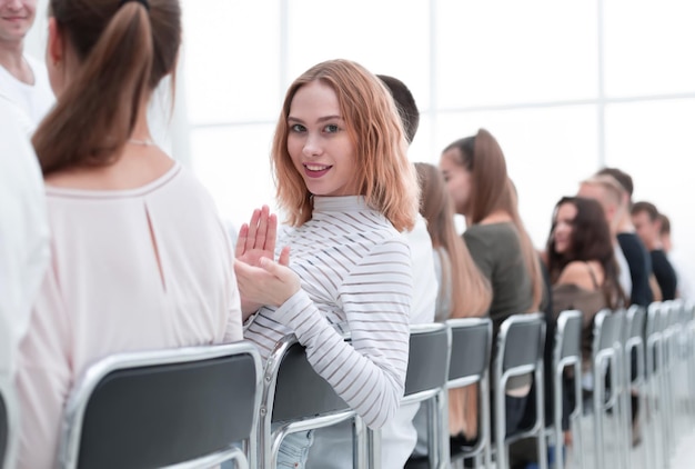 Foto primo piano giovane donna seduta in fila con i suoi soci