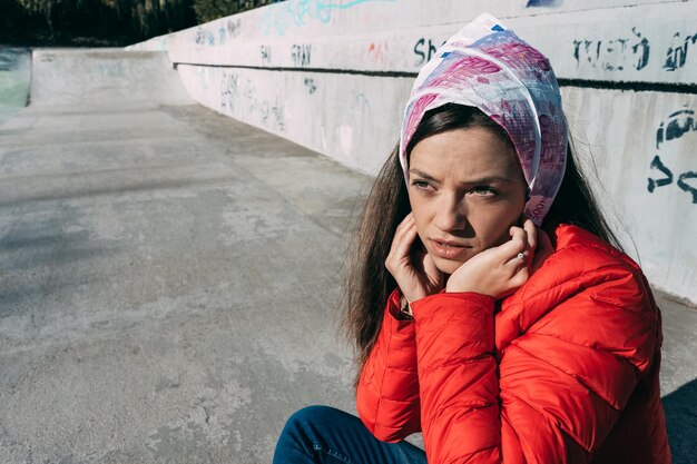 Photo close-up of young woman sitting at skateboard park