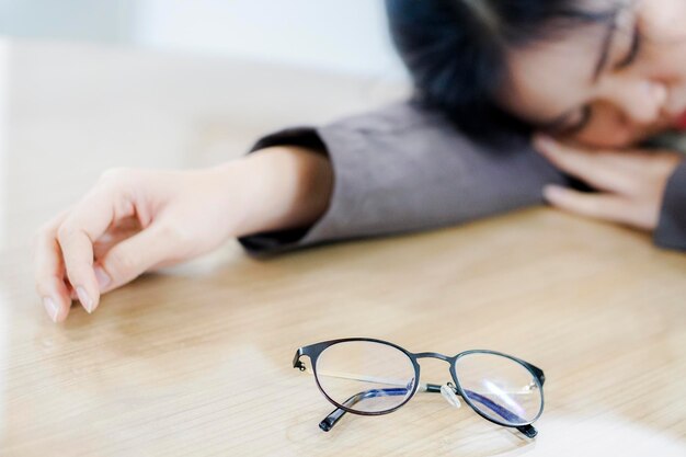 Foto close-up di una giovane donna che dorme sulla scrivania