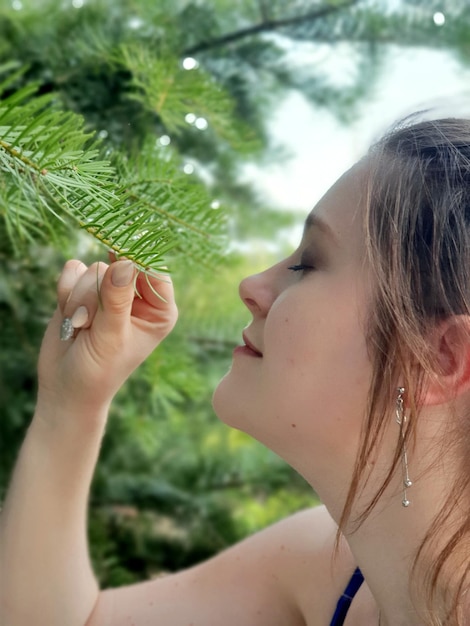 Foto close-up di una giovane donna che annusa la pianta