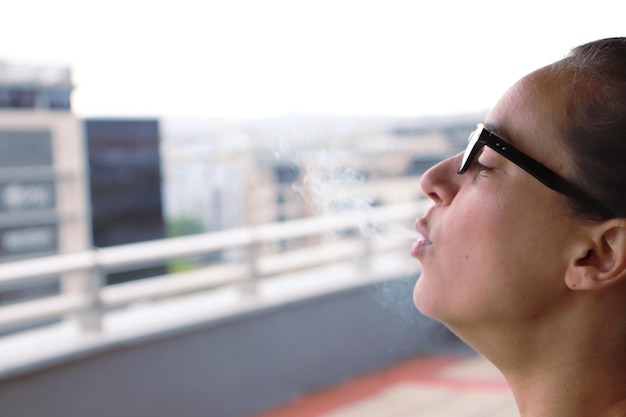 Foto close-up di una giovane donna che fuma